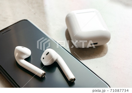 白いワイヤレスイヤホンとスマホ 71087734