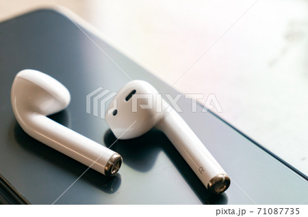 白いワイヤレスイヤホンとスマホ 71087735