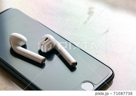 白いワイヤレスイヤホンとスマホ 71087736