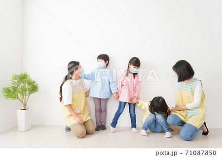 マスクを付けて幼稚園で遊ぶ子どもたちの先生 マスクを付けて幼稚園で遊ぶ子どもたちの先生 71087850