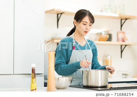キッチンで料理する若い女性 71088254