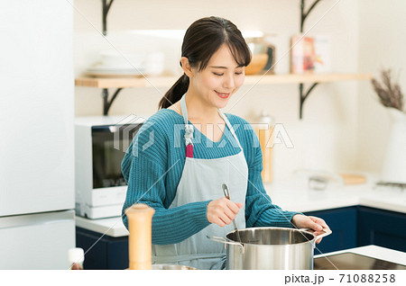 キッチンで料理する若い女性 キッチンで料理する若い女性 71088258