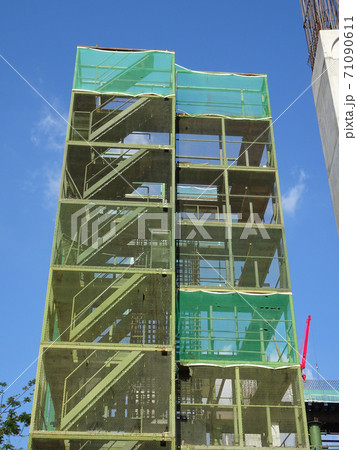SHAH ALAM, MALAYSIA -AUGUST 6, 2020: Temporary staircase and scaffolding are used in the construction of high concrete columns. Scaffolding is wrapped with safety netting for safety purposes. Installe SHAH ALAM, MALAYSIA -AUGUST 6, 2020: Temporary staircase and scaffolding are used in the construction of high concrete columns. Scaffolding is wrapped with safety netting for safety purposes. Installe 71090611
