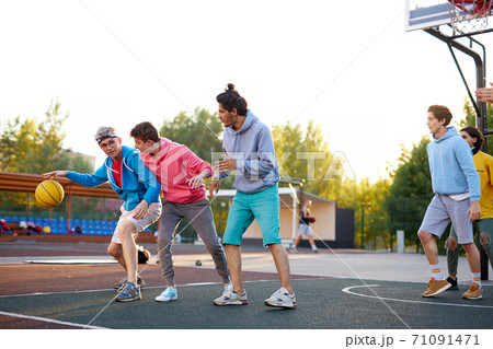 basketball players outdoors. summer vacation, holidays, games and friendship concept 71091471