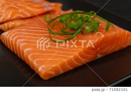 Slices of Raw Salmon Fillet on Black Background Slices of Raw Salmon Fillet on Black Background 71092101