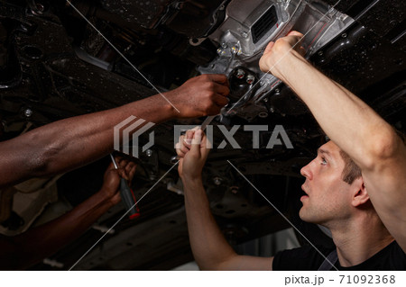view from below on men repairing car bottom view from below on men repairing car bottom 71092368