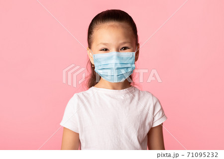 Girl in medical mask isolated over pink studio wall 71095232