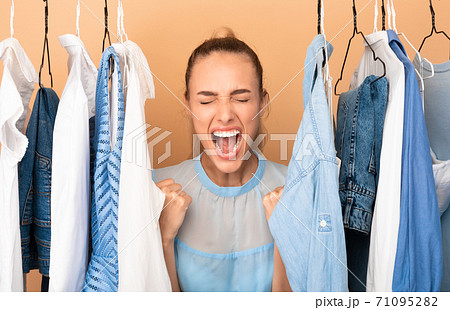 Portrait of excited lady screaming standing near rack Portrait of excited lady screaming standing near rack 71095282
