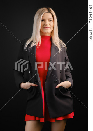 Pretty woman in red dress and black jacket posing Pretty woman in red dress and black jacket posing 71095404