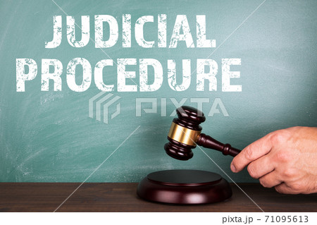 JUDICIAL PROCEDURE. Law and Legal concept. Judge's hammer and a green chalkboard 71095613