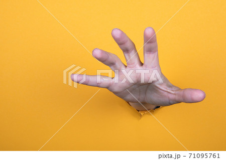 Hand reaches for help. Yellow paper background. Copy space Hand reaches for help. Yellow paper background. Copy space 71095761