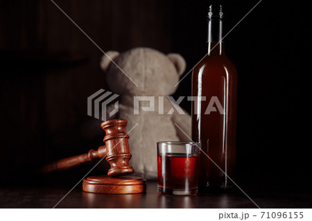 Alcohol in family and child abuse concept. Teddy bear as a symbol of child's safety, gavel and bottle with glass 71096155