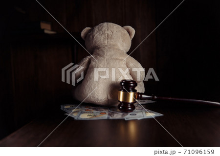Alimony payment. Dollar banknotes, judge gavel and teddy bear on a wooden table close-up. Family divorce and alimony concept 71096159