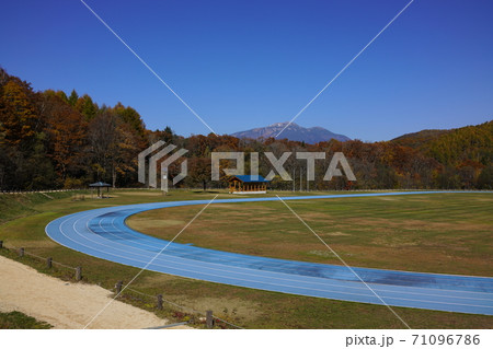 紅葉の高山市高根の日和田ハイランド陸上競技場と乗鞍岳 71096786