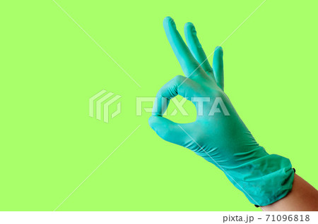 Female hand in blue latex glove makes a gesture resembling a dog with open mouth isolate malachite background. Medical health concept. 71096818