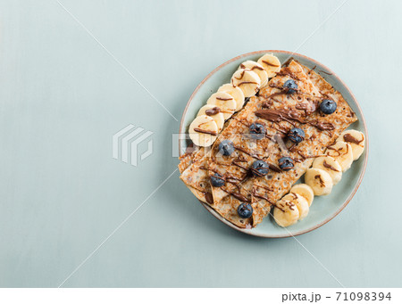 Crepes with chocolate nut spread, banana, berries 71098394