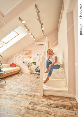 Pretty middle aged caucasian woman sitting on stairs 71099202