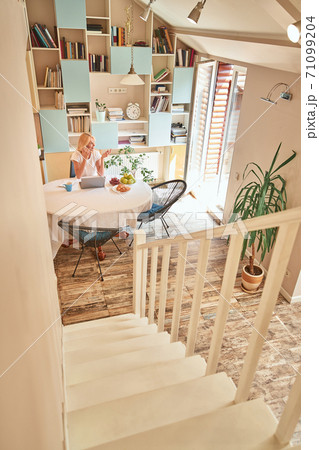 Middle aged caucasian business woman sitting at kitchen table Middle aged caucasian business woman sitting at kitchen table 71099204