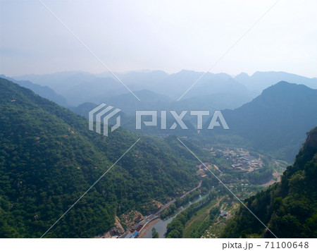 Aerial view of green mountain peak with beautiful blue sky. Aerial view of green mountain peak with beautiful blue sky. 71100648