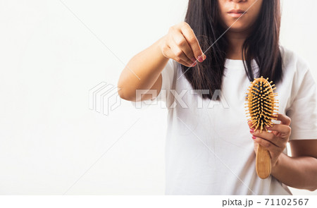 Woman weak hair her hold hairbrush with damaged long loss hair in the comb brush she pulls loss hair from brush Woman weak hair her hold hairbrush with damaged long loss hair in the comb brush she pulls loss hair from brush 71102567