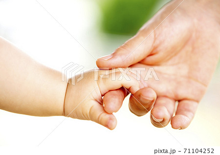 母親と赤ちゃんが手をつなぐ 親子の触れ合いの写真素材