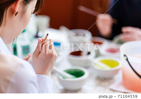 陶器の絵付け体験をする男女 71104559