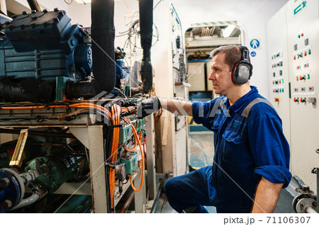 Marine engineer officer controlling vessel enginesand propulsion in engine control room ECR 71106307