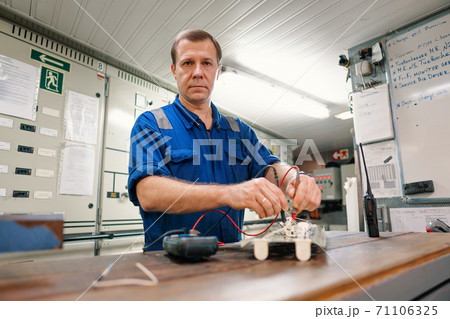 Marine electrical engineer officer in engine control room ECR. He works in workshop 71106325