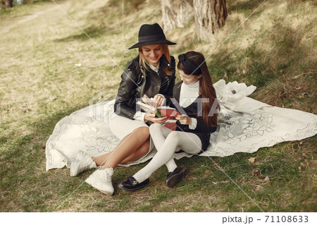 Elegant mother with daughter in a summer forest 71108633