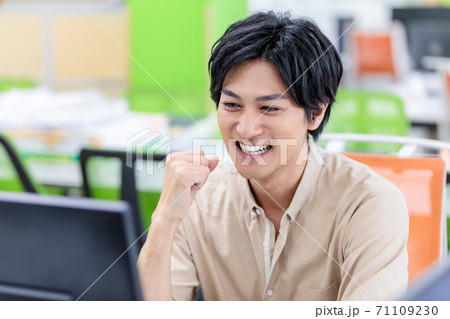 オフィスで朗報にガッツポーズをする男性 71109230