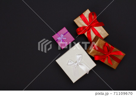 Gift boxes with ribbons on black background. Gift boxes with ribbons on black background. 71109670