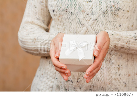 Woman holding a white gift box in the hands. Woman holding a white gift box in the hands. 71109677