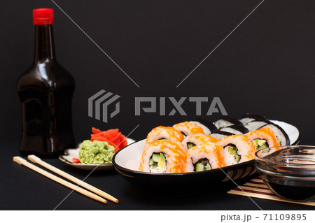 Uramaki California. Sushi rolls, bottle and bowl with soy sauce. Uramaki California. Sushi rolls, bottle and bowl with soy sauce. 71109895