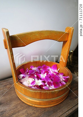 お風呂に浮かべるランの花が入った桶の写真素材
