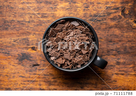 Grated dark chocolate. Chocolate flakes in cup. Grated dark chocolate. Chocolate flakes in cup. 71111788