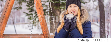 Woman drinks tea from a thermos on a winter day BANNER, LONG FORMAT Woman drinks tea from a thermos on a winter day BANNER, LONG FORMAT 71112982