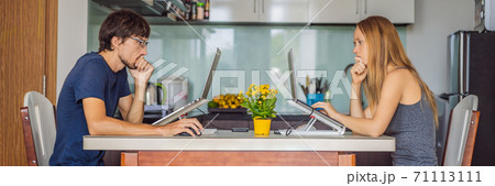 Man and woman working at home in the kitchen during quarantine COVID 19 BANNER, LONG FORMAT Man and woman working at home in the kitchen during quarantine COVID 19 BANNER, LONG FORMAT 71113111