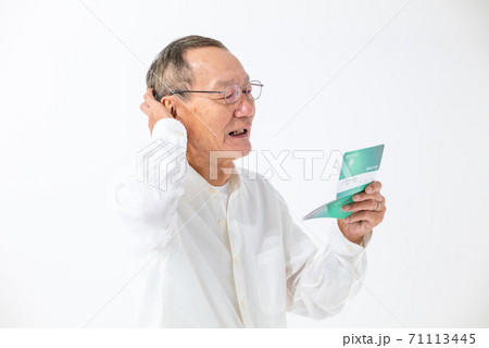 通帳の残高を見るシニア男性 71113445