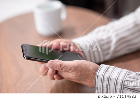 スマートフォンを持つ男性の手元 スマートフォンを持つ男性の手元 71114832