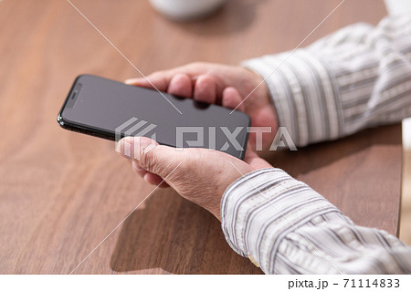 スマートフォンを持つ男性の手元 71114833