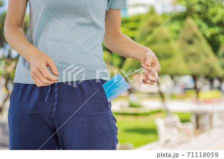 Improper wearing of mask concept. Woman wants to wear an old, crumpled used mask 71118059