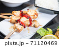 Traditional, oriental and Asian kebabs on a wooden skewer of grilled chicken pieces boiled rice as a garnish. 71120469