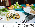 Fillet of white fish sea bass, cod stuffed with greens and rice on the table in the restaurant. 71120479
