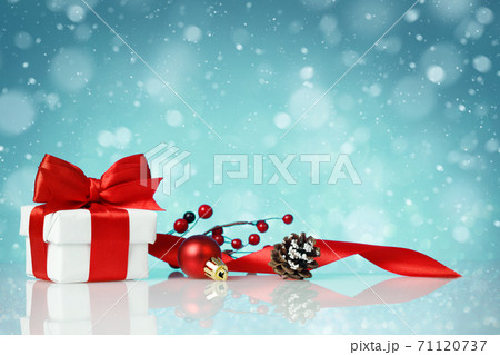 Decorative red gift box with a white bow with chtistmas decorations Decorative red gift box with a white bow with chtistmas decorations 71120737