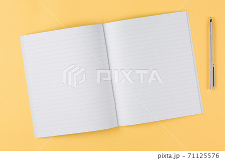 notebook with black pen on yellow background 71125576