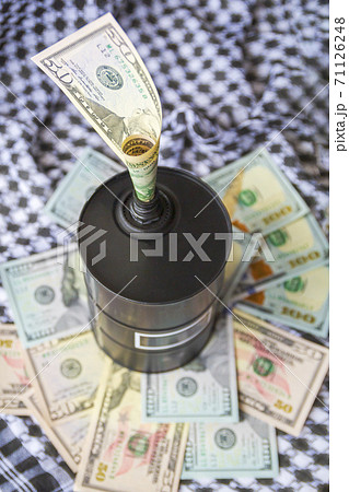 Barrel of oil on a background, american dollars and arabian background. Falling trend of barrel price decrease of earning and global economics . Selective focus. 71126248