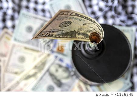 Barrel of oil on a background, american dollars and arabian background. Falling trend of barrel price decrease of earning and global economics . Selective focus. 71126249