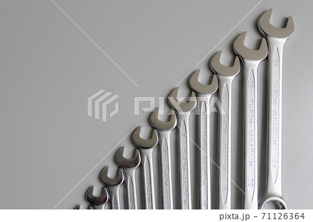 Spanners. Many wrenches. Grey background. Set of wrenches in different sizes on grey background. 71126364