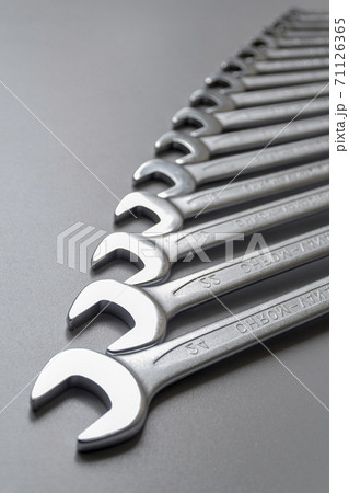 Spanners. Many wrenches. Grey background. Set of wrenches in different sizes on grey background. Vertical format. Spanners. Many wrenches. Grey background. Set of wrenches in different sizes on grey background. Vertical format. 71126365