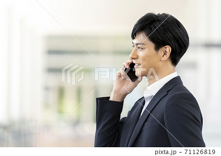 スマートフォンで通話する30代の男性の横顔 71126819